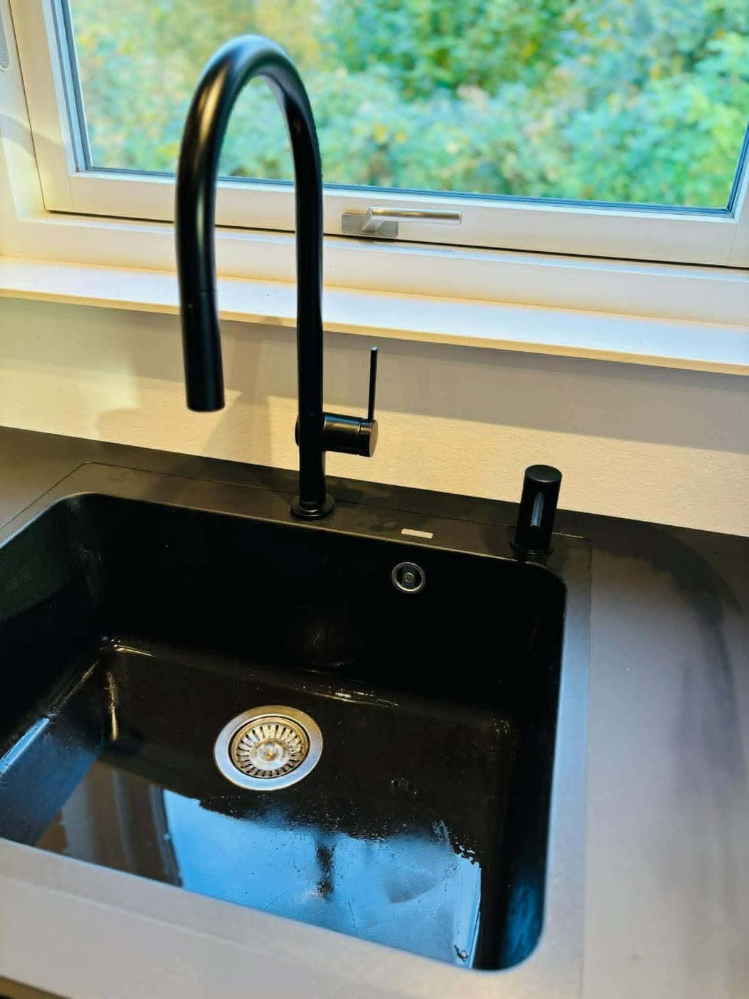 Sort køkkenvask med sort armatur, monteret af MM Energi